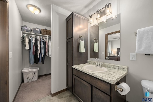 5520 S Seville Pl, Sioux Falls, SD 57108 - bathroom featuring vanity, toilet, a spacious closet, and baseboards