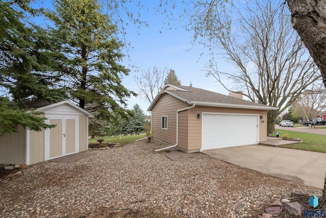 1304 N Tahoe Trl, Sioux Falls, SD 57110 - view of property exterior featuring a chimney, a detached garage, and roof with shingles