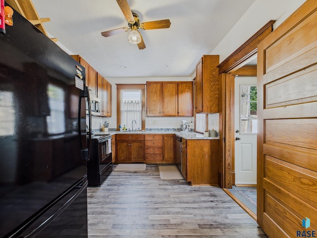 318 W 19th St, Sioux Falls, SD 57105 - kitchen with black appliances, ceiling fan, light wood-style floors, light countertops, and brown cabinets