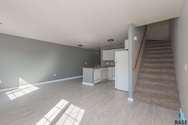 6501 S Santa Rosa Pl, Sioux Falls, SD 57108 - unfurnished living room with baseboards, light wood-style floors, stairway, and a sink