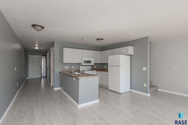 6501 S Santa Rosa Pl, Sioux Falls, SD 57108 - kitchen with white appliances, a sink, a peninsula, white cabinetry, and light wood-style flooring