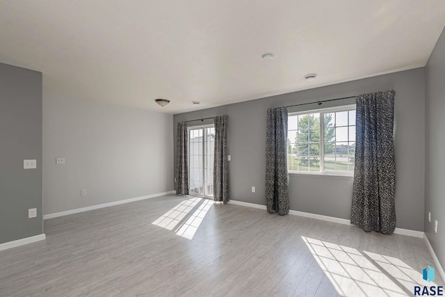 6501 S Santa Rosa Pl, Sioux Falls, SD 57108 - empty room featuring light wood finished floors, baseboards, and a smoke detector