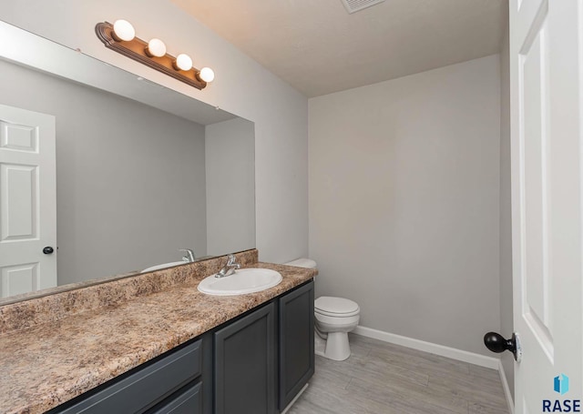 6501 S Santa Rosa Pl, Sioux Falls, SD 57108 - half bath with vanity, wood finished floors, toilet, and baseboards