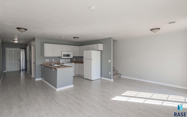 6501 S Santa Rosa Pl, Sioux Falls, SD 57108 - kitchen featuring white appliances, a sink, baseboards, and a peninsula