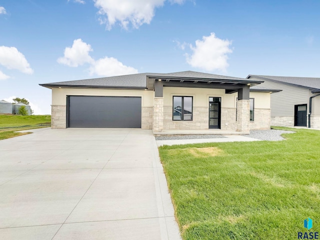 413 W 5th St, Crooks, SD 57020 - prairie-style house with stone siding, driveway, a garage, a front lawn, and stucco siding