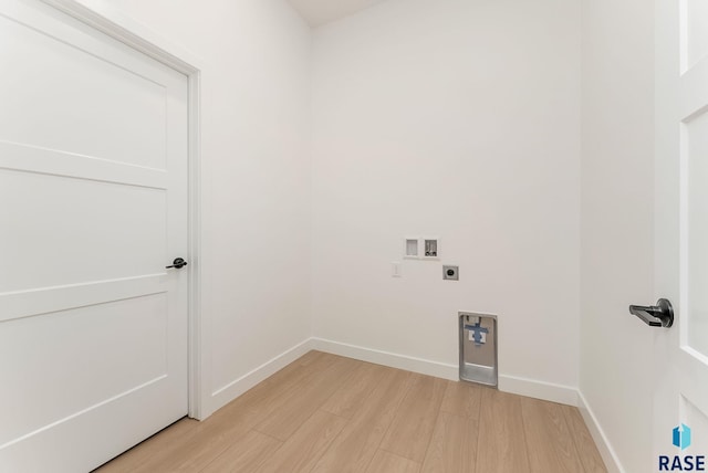 413 W 5th St, Crooks, SD 57020 - laundry area with light wood-style flooring, electric dryer hookup, hookup for a washing machine, and baseboards