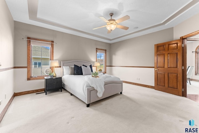 417 E Meadowlark Cir, Brandon, SD 57005 - bedroom featuring a raised ceiling, baseboards, light carpet, and ceiling fan