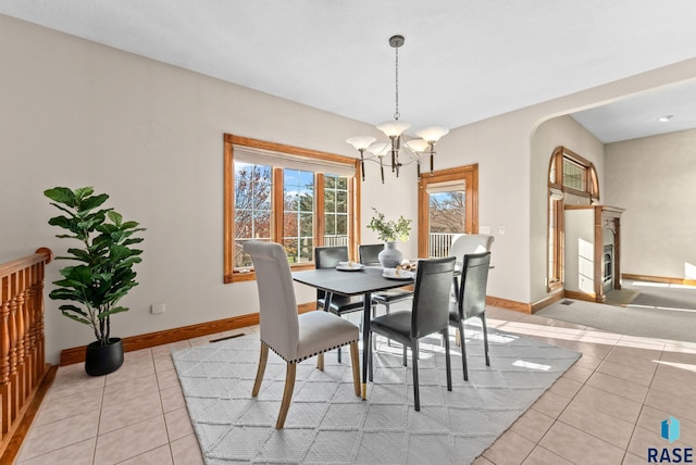 417 E Meadowlark Cir, Brandon, SD 57005 - dining area featuring light tile patterned flooring, a chandelier, baseboards, and arched walkways