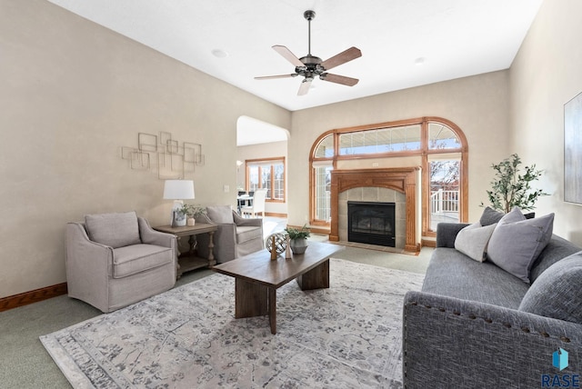417 E Meadowlark Cir, Brandon, SD 57005 - living area featuring carpet floors, a ceiling fan, a tile fireplace, baseboards, and arched walkways