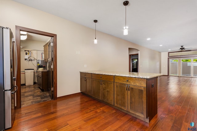 301 S Spring Pl, Brandon, SD 57005 - kitchen featuring freestanding refrigerator, arched walkways, a peninsula, ceiling fan, and dark wood finished floors