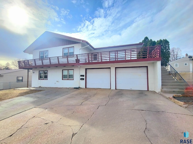 3605 E 18th St, Sioux Falls, SD 57103 - view of front facade featuring concrete driveway, stucco siding, a garage, and a balcony