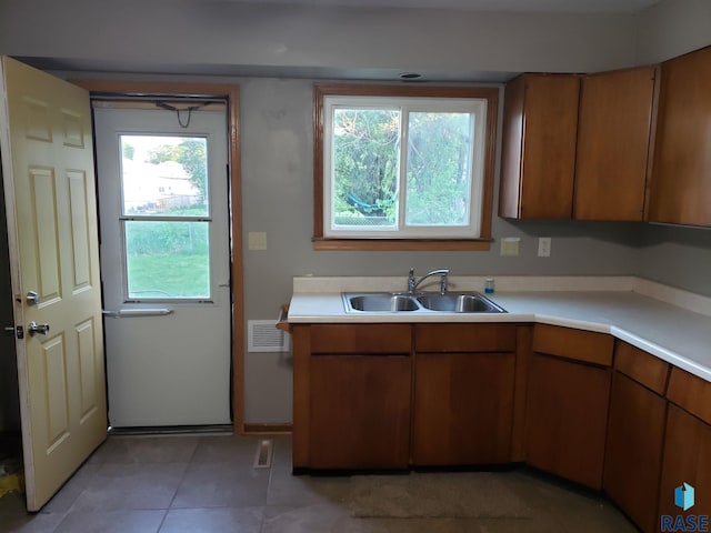 3605 E 18th St, Sioux Falls, SD 57103 - kitchen featuring a sink, light countertops, brown cabinets, and light tile patterned flooring