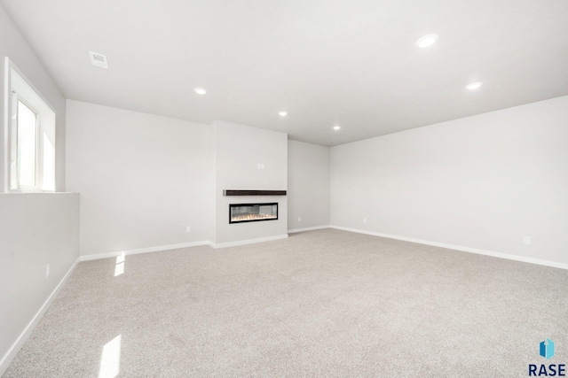 2900 S Copper Creek Ave, Sioux Falls, SD 57110 - unfurnished living room featuring carpet flooring, recessed lighting, baseboards, and a glass covered fireplace