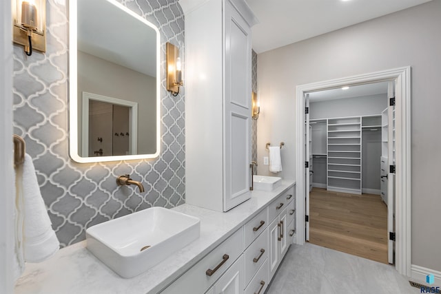 2720 S Oriya Pl, Sioux Falls, SD 57106 - full bath featuring double vanity, a spacious closet, and baseboards