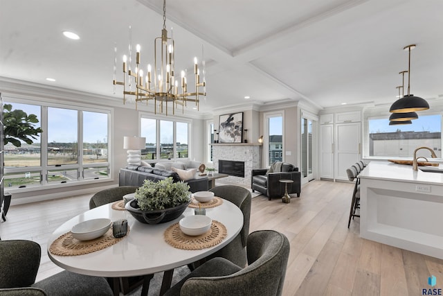 2720 S Oriya Pl, Sioux Falls, SD 57106 - dining area with crown molding, a stone fireplace, light wood-style flooring, recessed lighting, and a chandelier