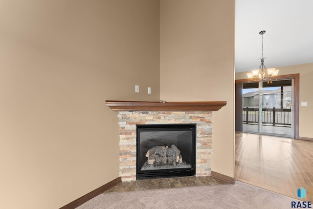 7005 E Archstone St, Sioux Falls, SD 57110 - detailed view of a chandelier, a stone fireplace, baseboards, and carpet