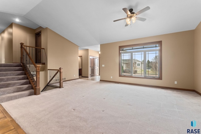 7005 E Archstone St, Sioux Falls, SD 57110 - unfurnished living room with lofted ceiling, baseboards, a ceiling fan, and light colored carpet