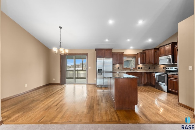 7005 E Archstone St, Sioux Falls, SD 57110 - kitchen with appliances with stainless steel finishes, a center island, a chandelier, light wood finished floors, and vaulted ceiling