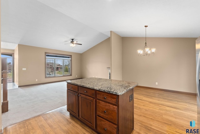 7005 E Archstone St, Sioux Falls, SD 57110 - kitchen with light wood finished floors, a ceiling fan, baseboards, a kitchen island, and a chandelier