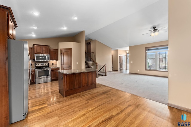 7005 E Archstone St, Sioux Falls, SD 57110 - kitchen featuring appliances with stainless steel finishes, open floor plan, light wood-style flooring, lofted ceiling, and ceiling fan