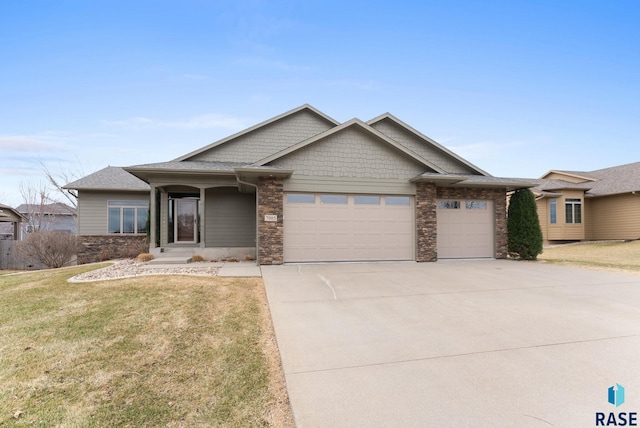 7005 E Archstone St, Sioux Falls, SD 57110 - view of front facade with a garage, stone siding, driveway, and a front lawn