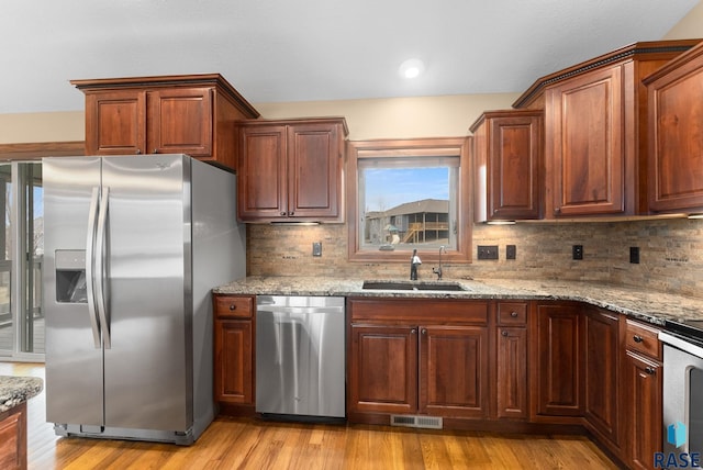 7005 E Archstone St, Sioux Falls, SD 57110 - kitchen featuring appliances with stainless steel finishes, a sink, and light stone countertops