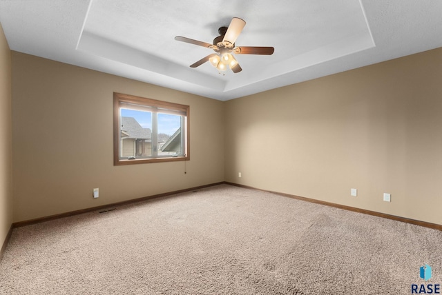 7005 E Archstone St, Sioux Falls, SD 57110 - unfurnished room with a tray ceiling, light colored carpet, ceiling fan, and baseboards