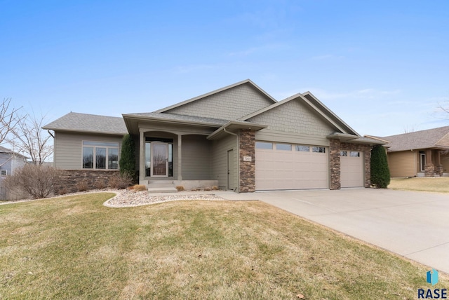 7005 E Archstone St, Sioux Falls, SD 57110 - view of front of home featuring an attached garage, concrete driveway, a front lawn, stone siding, and a shingled roof