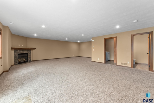 7005 E Archstone St, Sioux Falls, SD 57110 - unfurnished living room with baseboards, carpet floors, a fireplace with flush hearth, and recessed lighting