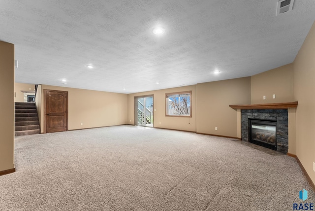 7005 E Archstone St, Sioux Falls, SD 57110 - unfurnished living room with stairway, a fireplace with flush hearth, baseboards, recessed lighting, and a textured ceiling