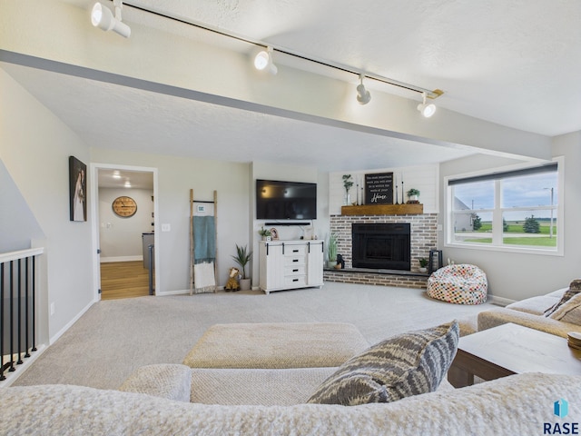 577 60th Ave, Beaver Creek, MN 56116 - living room featuring carpet, a brick fireplace, track lighting, and baseboards