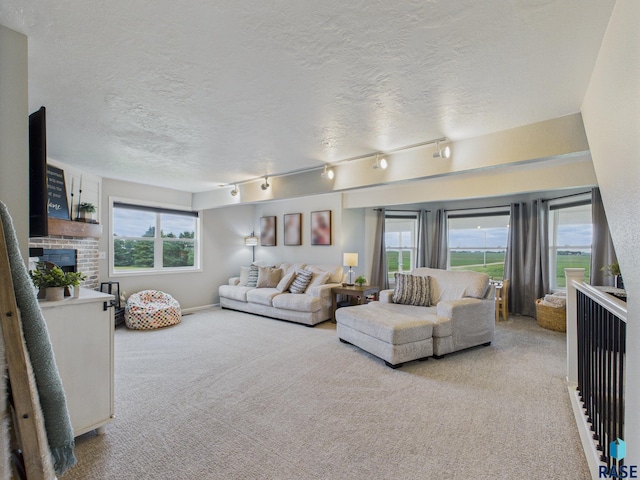 577 60th Ave, Beaver Creek, MN 56116 - living area featuring light colored carpet, a brick fireplace, a textured ceiling, and track lighting
