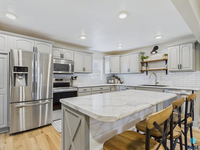 577 60th Ave, Beaver Creek, MN 56116 - kitchen featuring appliances with stainless steel finishes, a sink, a kitchen bar, light wood finished floors, and recessed lighting