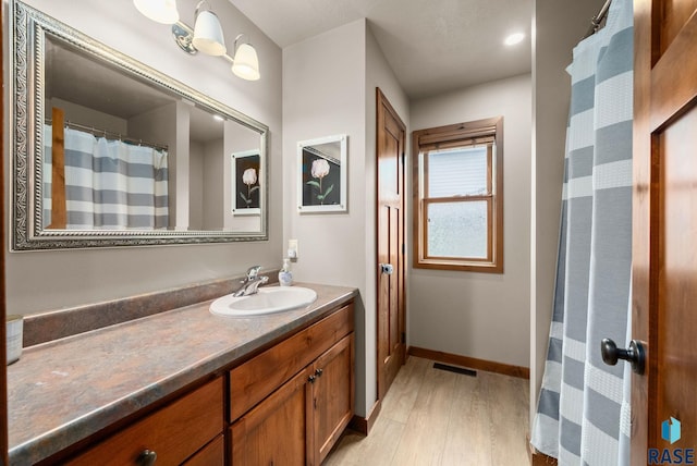 1325 W Whitechurch Ln, Sioux Falls, SD 57108 - bathroom with wood finished floors, vanity, and baseboards