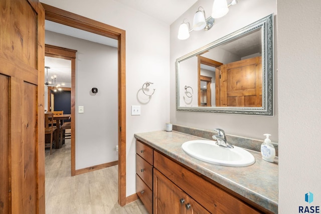 1325 W Whitechurch Ln, Sioux Falls, SD 57108 - bathroom with vanity, wood finished floors, and baseboards