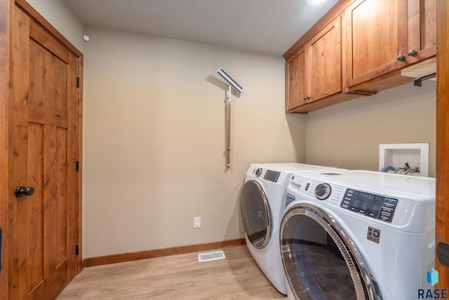 1325 W Whitechurch Ln, Sioux Falls, SD 57108 - washroom with washing machine and clothes dryer, cabinet space, light wood-style floors, and baseboards