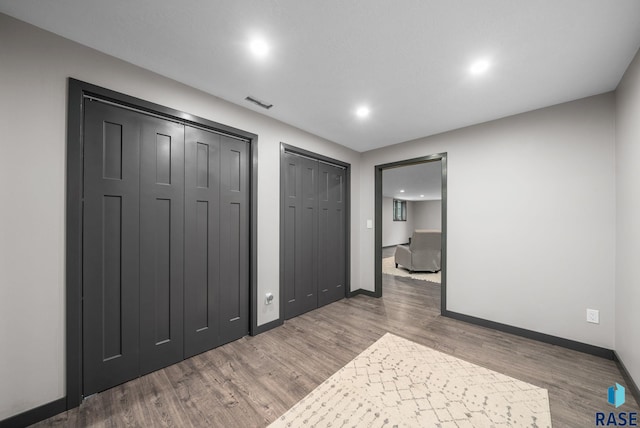 1325 W Whitechurch Ln, Sioux Falls, SD 57108 - unfurnished bedroom with two closets, recessed lighting, wood finished floors, and baseboards