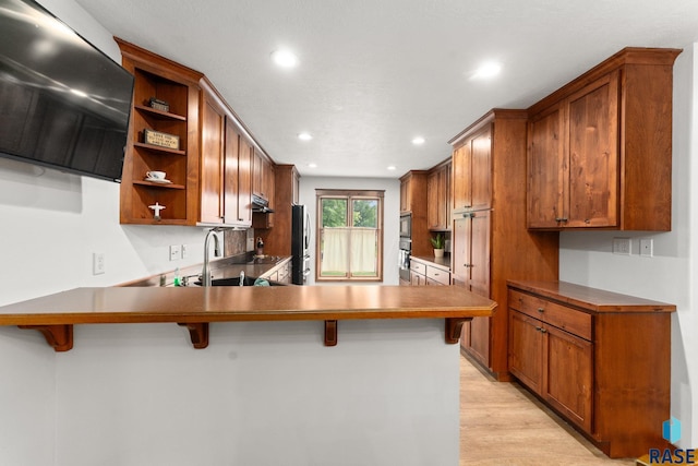 1325 W Whitechurch Ln, Sioux Falls, SD 57108 - kitchen featuring open shelves, a peninsula, recessed lighting, under cabinet range hood, and a breakfast bar area