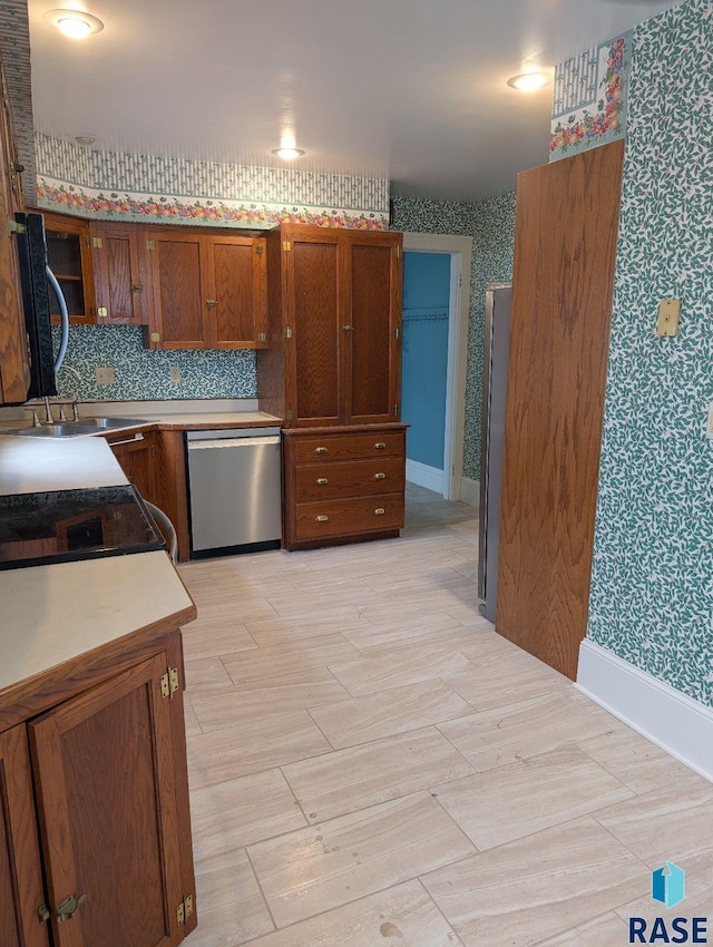 302 E 19th St, Sioux Falls, SD 57105 - kitchen featuring dishwasher, wallpapered walls, a sink, brown cabinetry, and electric range