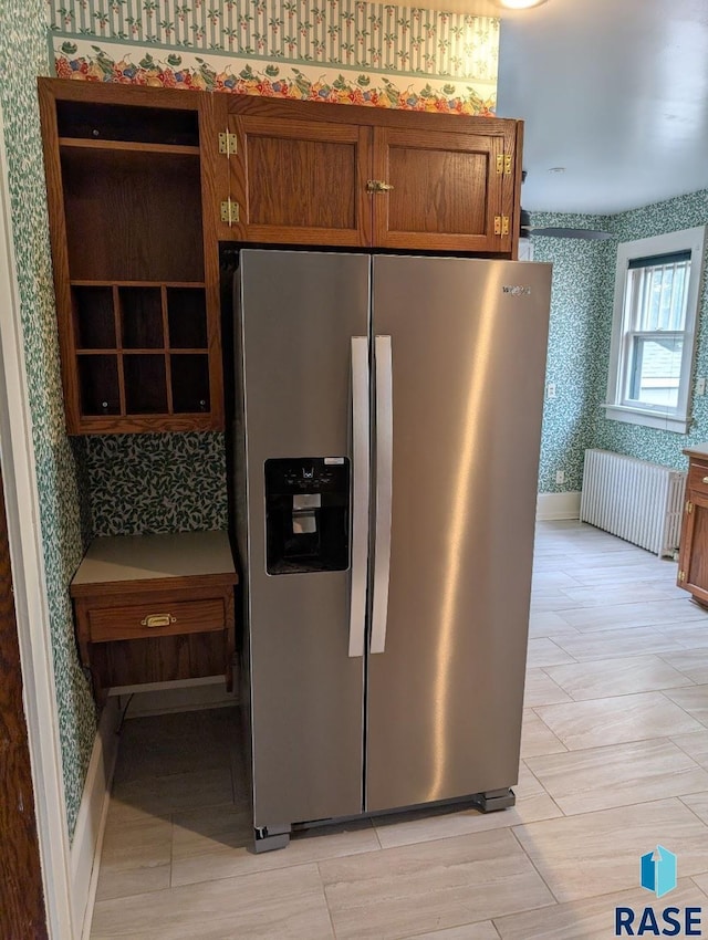 302 E 19th St, Sioux Falls, SD 57105 - kitchen featuring stainless steel fridge with ice dispenser, wallpapered walls, brown cabinetry, radiator heating unit, and baseboards