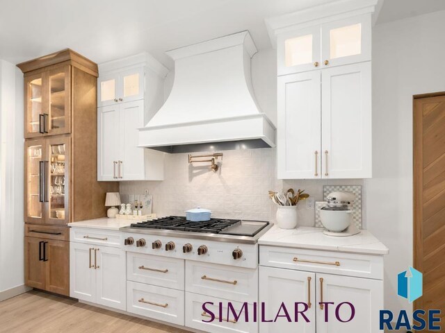 1112 N Slate Ave, Brandon, SD 57005 - kitchen with wall chimney range hood, gas cooktop, decorative backsplash, light stone counters, and white cabinetry