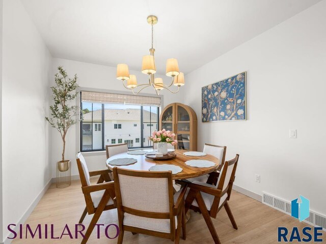 1112 N Slate Ave, Brandon, SD 57005 - dining area with a chandelier, light wood-style flooring, and baseboards