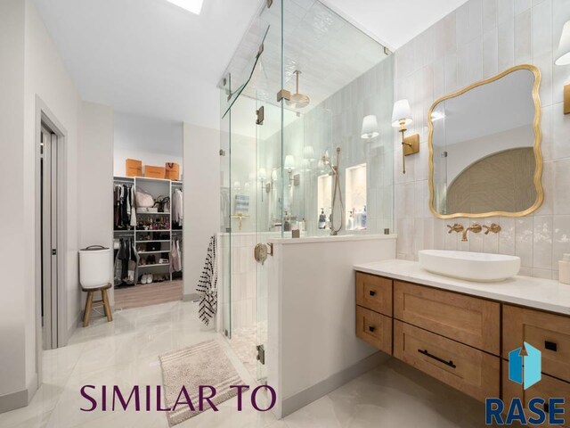 1112 N Slate Ave, Brandon, SD 57005 - bathroom featuring a shower stall, a walk in closet, vanity, and tile walls