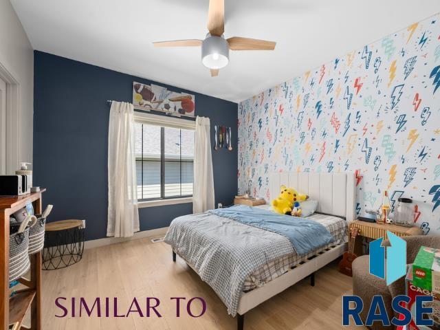 1112 N Slate Ave, Brandon, SD 57005 - bedroom with wood finished floors, baseboards, an accent wall, and a ceiling fan