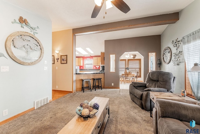 27549 475th Ave, Worthing, SD 57077 - living room featuring light colored carpet, a ceiling fan, baseboards, and beam ceiling