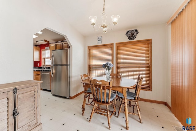 27549 475th Ave, Worthing, SD 57077 - dining space with light flooring, a chandelier, baseboards, and arched walkways