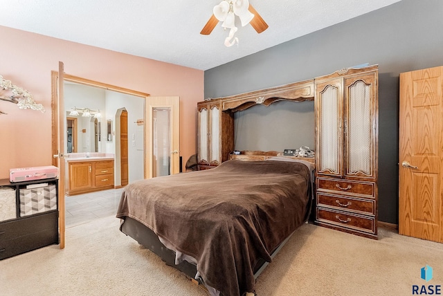 27549 475th Ave, Worthing, SD 57077 - bedroom with light colored carpet, arched walkways, a ceiling fan, and ensuite bath