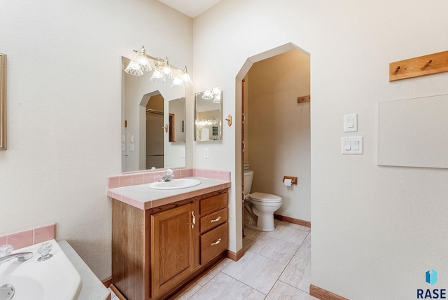 27549 475th Ave, Worthing, SD 57077 - full bathroom with vanity, toilet, tile patterned floors, a tub, and baseboards