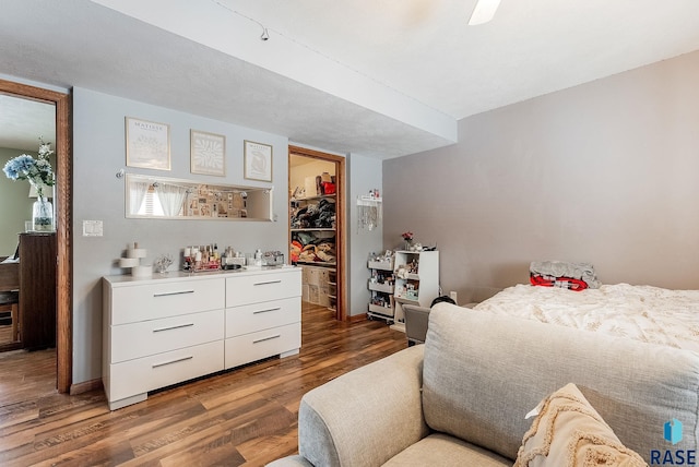 27549 475th Ave, Worthing, SD 57077 - bedroom with wood finished floors, a walk in closet, a closet, ceiling fan, and baseboards