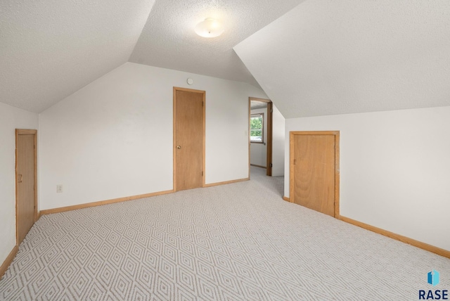 1422 E 17th St, Sioux Falls, SD 57104 - bonus room featuring vaulted ceiling, light colored carpet, a textured ceiling, and baseboards